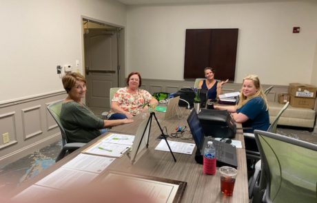 Photo image of The registration table is the place to be. Pictured left to right is Sandy Richards, Secretary, Donna Hedger, Awards Chair, Norba Targa, Treasurer, and Amanda Knowles, GSH Webmaster.